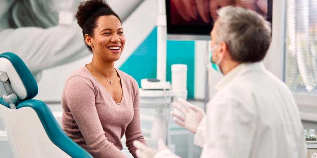 Dentist talking to smiling patient